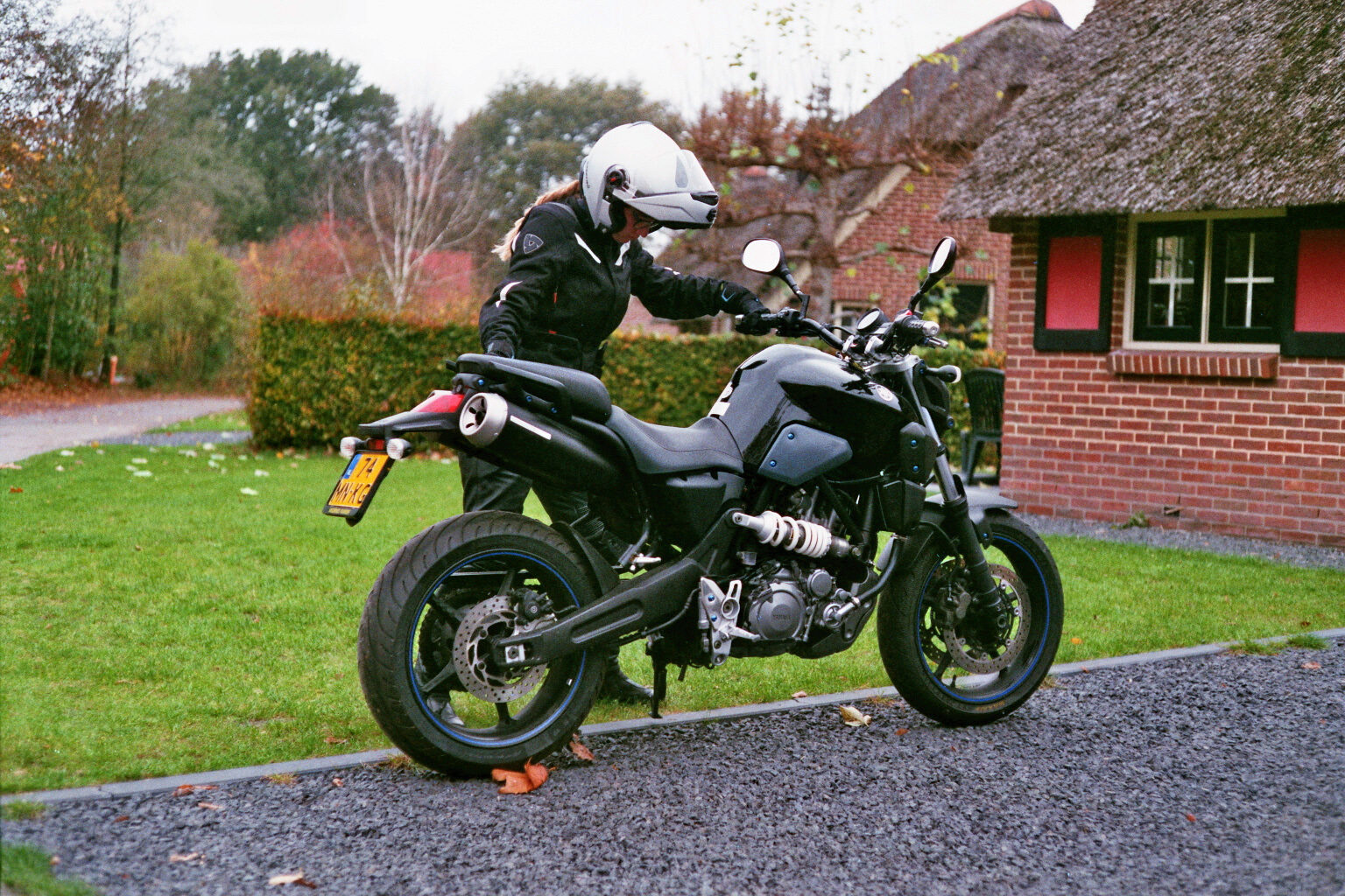 Gast op motor arriveert Gast parkeert motor bij vakantiehuis
