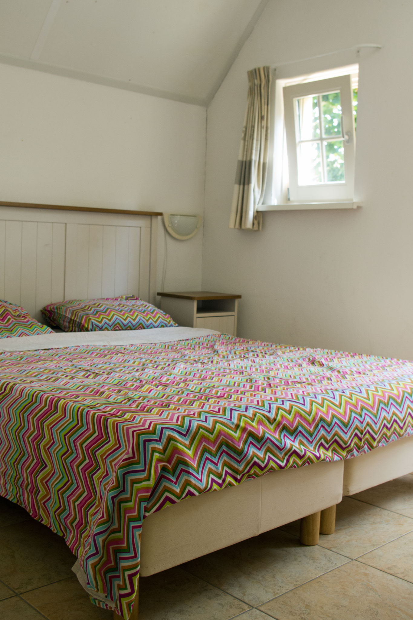 Twee eenpersoonsbedden naast elkaar in de slaapkamer beneden die naast elkaar zijn gezet en opgedekt als een tweepersoons bed.