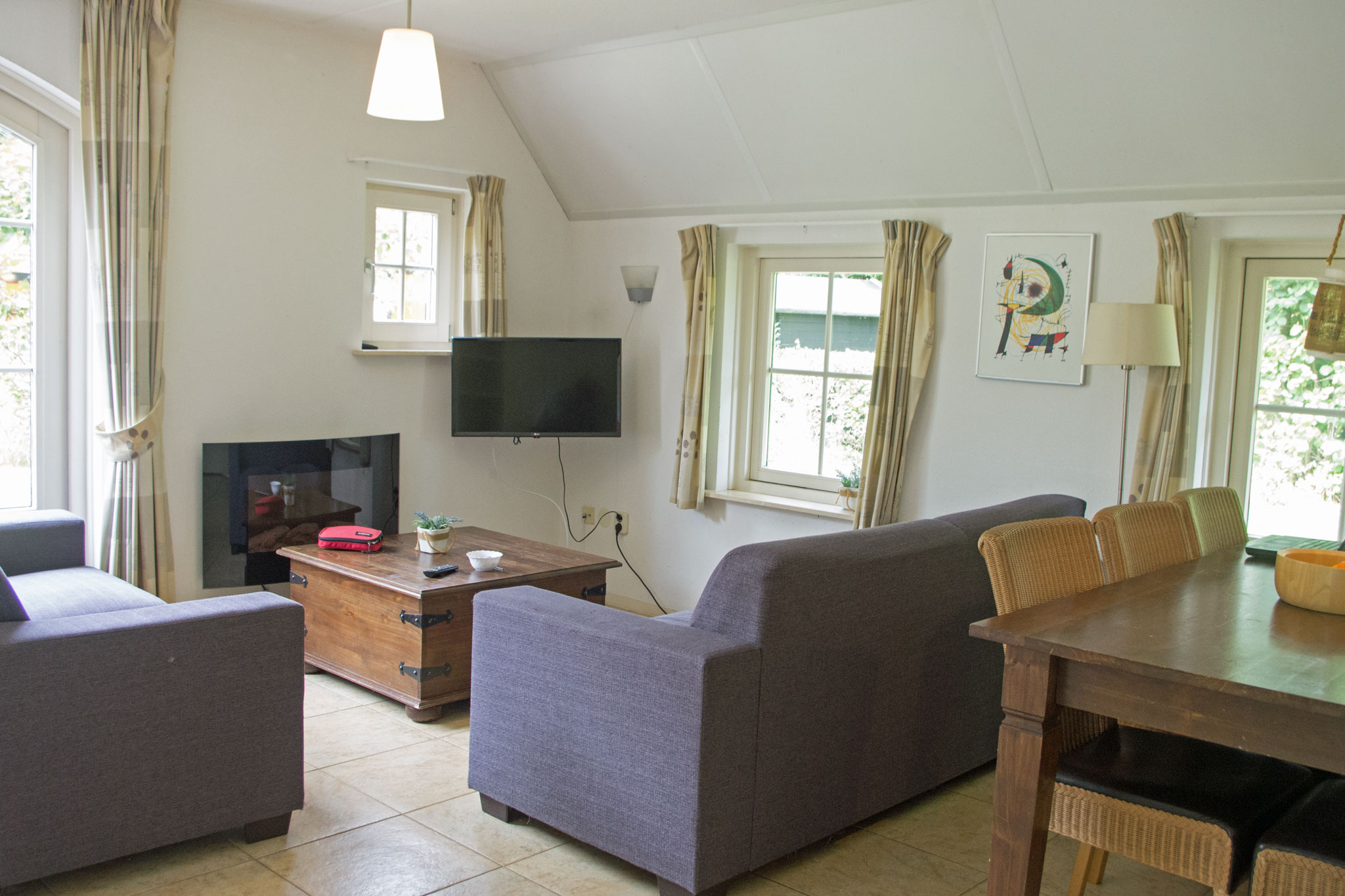 Woonkamer met eettafel, bank, sfeerhaard en TV